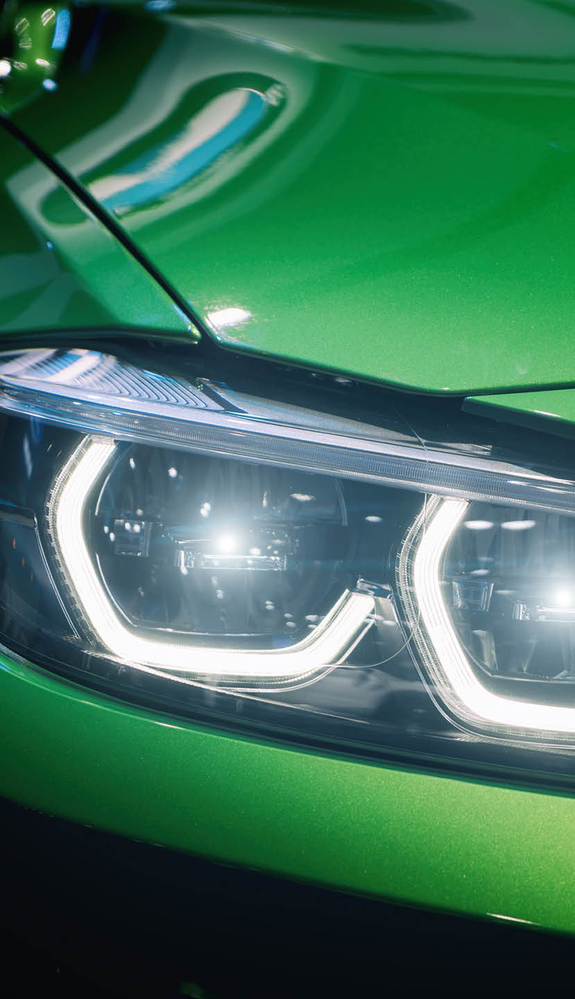 Closeup headlights of modern car during turn on light in night.
