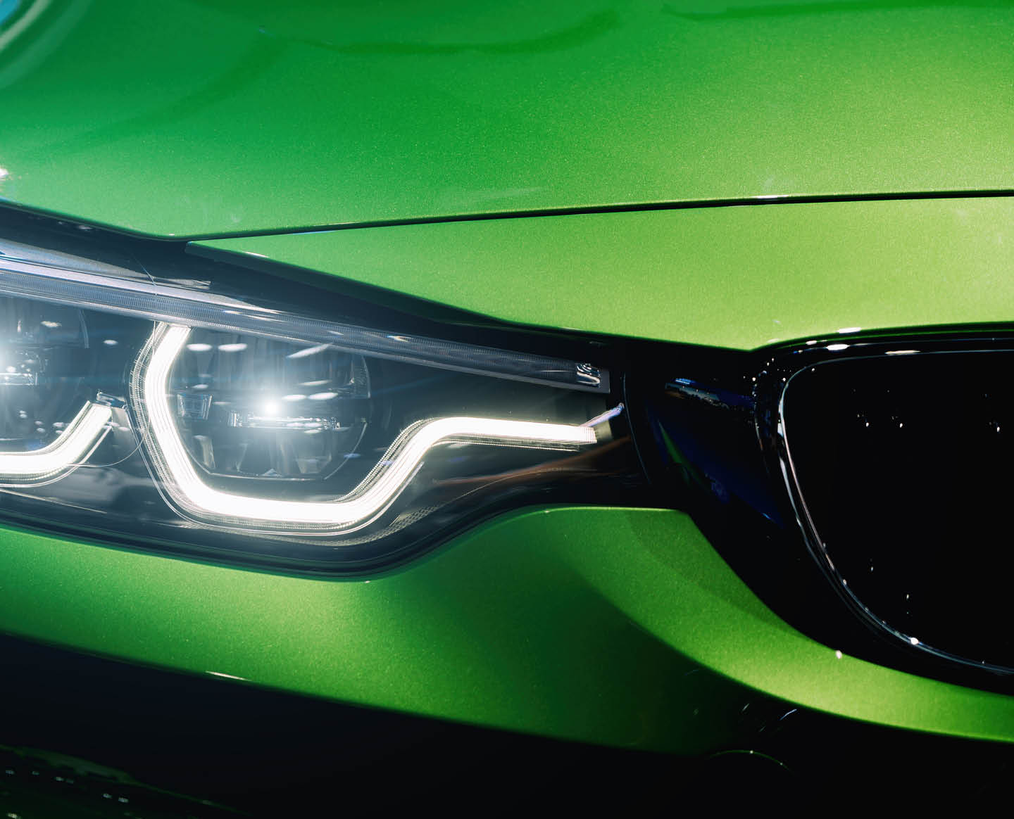 Closeup headlights of modern car during turn on light in night.
