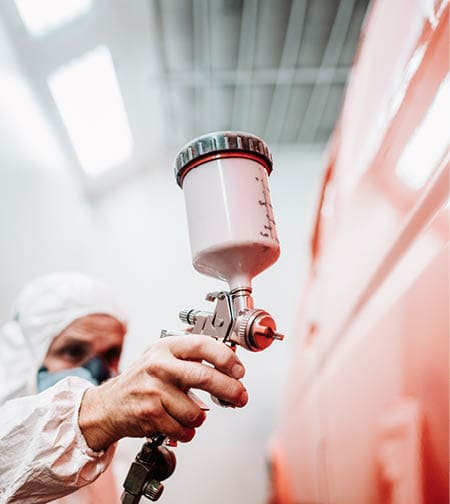 close up of paint spray gun, worker painting a car