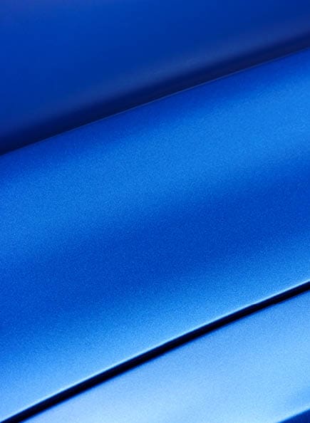 Surface of blue sport sedan car metal hood; part of vehicle bodywork 